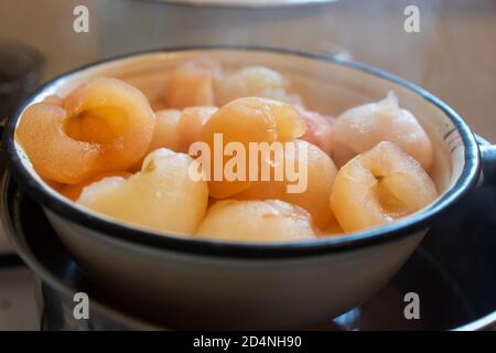 freshly boiled peeled hot apples in colander Stock Photo