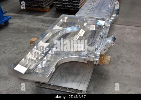Silver bent aluminium profile. Fragment of alu products. Detail of stainless steel background, texture. Production of aluminum enclosures for trains a Stock Photo