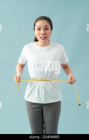 astonished slim woman measuring her waist Stock Photo