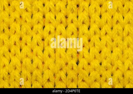 Yellow synthetic knitted fabric close up. Knitted fabric texture background Stock Photo