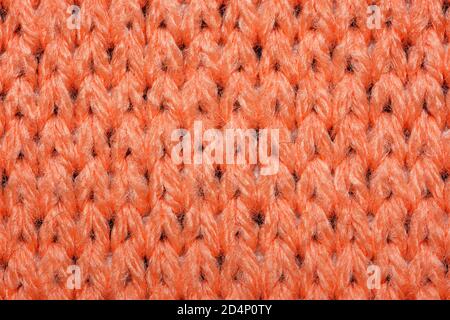 Red synthetic knitted fabric close up. Knitted fabric texture background Stock Photo