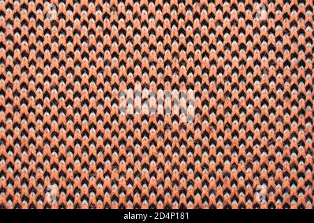 Synthetic knitted fabric with pattern elements of red, black and white yarns close up. Patterned knitted fabric texture background Stock Photo
