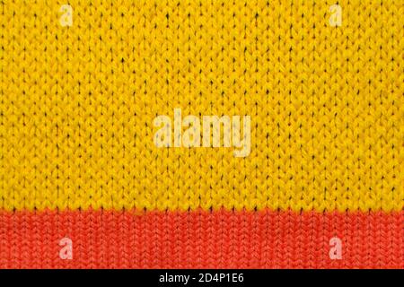 Yellow and red synthetic knitted fabric close up. Knitted fabric texture background Stock Photo