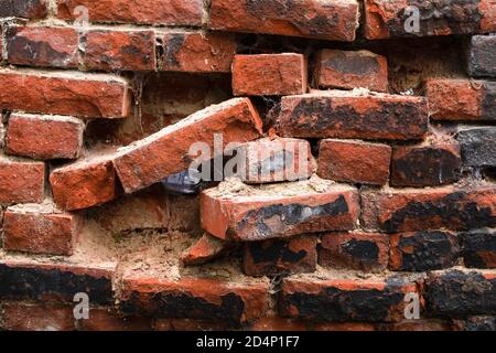 Empty vodka bottles hidden in a breach in old medieval brick wall. Gniezno, Poland. Stock Photo