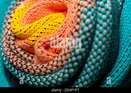 Twisted folds of colorful knitted fabrics of winter clothes with different structures and textures. Smooth shapes background. Smooth folded multi colo Stock Photo