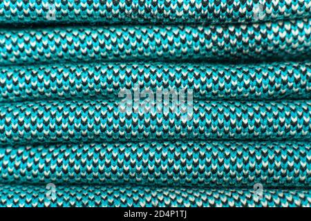 Stack of blue knitted fabric, knitted winter clothes. Folded synthetic knitted fabric with pattern elements of blue, black and white yarns close up. M Stock Photo