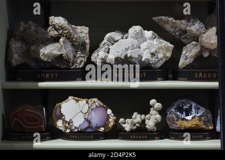 Collection of minerals on display in the Hall of Minerals in the National Museum (Národní muzeum) in Prague, Czech Republic. Baryte, witherite, agate, chalcedon and quartz are displayed in the case from left to right from upper shelf to the lower shelf. Stock Photo