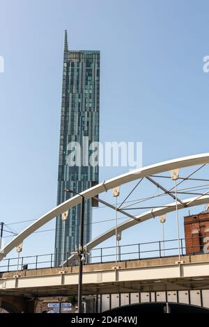 Tall building of Beetham Tower with metal arches of tram bridge with foreground in Manchester city centre. Stock Photo