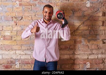 A handsome young man listening to music on a wireless speaker. Stock Photo