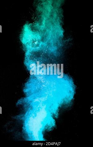 Launched blue dust particles splashing.Bizarre forms of blue powder explosion cloud on white background. Stock Photo