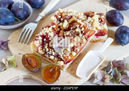 plum slice with crumble topping on wooden board Stock Photo
