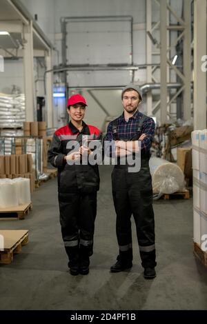 Successful young male and female engineers of large contemporary plant Stock Photo