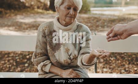 Old poor woman getting some coins from passenger. High quality photo Stock Photo