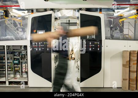 Blurred motion of male worker of contemporary factory carrying large detail Stock Photo
