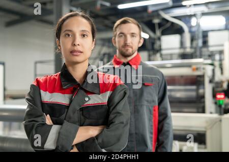 Young serious pretty female leader of workteam keeping her arms crossed by chest Stock Photo