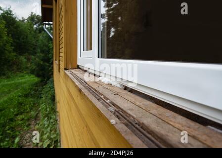 Montage of new plastic window into old rustic house. Stock Photo