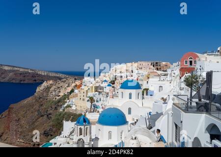 View of Santorini, with typical blue dome church, old whitewashed houses and caldera. Greek landscape on a sunny day Stock Photo