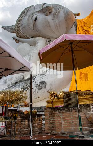 AYUTTHAYA, THAILAND, JUN 03 2020, The umbrellas under head of the reclining Buddha covered with the golden fabric, Wat Khun Inthapramun. Stock Photo