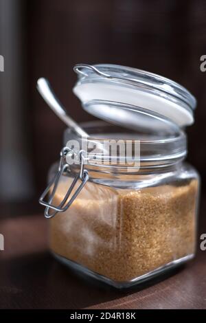 Transparent glass jar with brown sugar cane on a black background Stock Photo