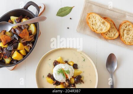 Thick creamy soup with fresh forest mushrooms, poached eggs and potatoes. Favourite season mushroom lunch or dinner in Czech Republic. Stock Photo