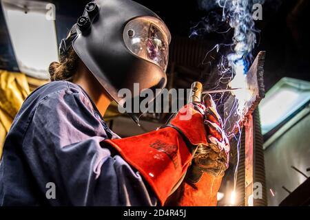 SEA OF JAPAN (Jan. 14, 2020) Hull Maintenance Technician 2nd Class Katrina Sennett, from Wilkes-Barre, Pa., practices welding on a vertical beveled test plate in the general workshop aboard the Arleigh Burke-class guided-missile destroyer USS Milius (DDG 69). Milius is underway conducting operations in the Indo-Pacific region while assigned to Destroyer Squadron (DESRON) 15, the Navy’s largest forward-deployed DESRON and the U.S. 7th Fleet’s principal surface force. (U.S. Navy photo by Mass Communication Specialist 2nd Class Taylor DiMartino) Stock Photo