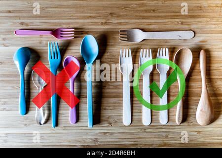 Illustration on the prohibition of disposable plastic cutlery and the replacement by disposable wooden cutlery. Stock Photo