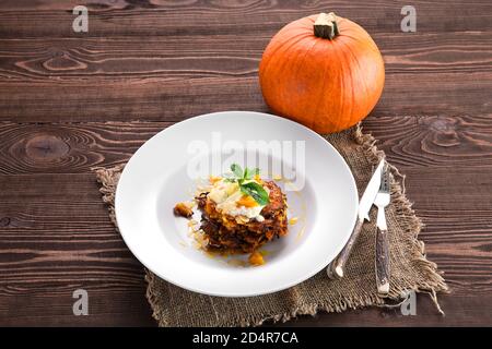 Sweet pumpkin fritters with yogurt with whole pumpkin on background Stock Photo