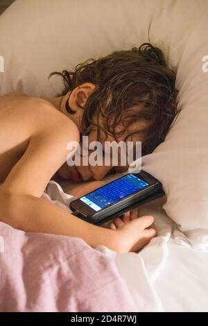 5 year old boy playing with a smartphone. Stock Photo