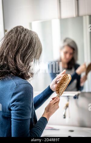 Woman brushing her hair. Stock Photo