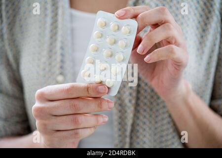 Woman taking an hormone replacement therapy pills. Stock Photo