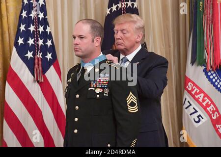 President Donald J. Trump presents the Medal of Honor to U.S. Army Master Sgt. Matthew O. Williams during a ceremony at the White House in Washington, D.C., Oct. 30, 2019. Williams was awarded the Medal of Honor for his actions while serving as a weapons sergeant with the Special Forces Operational Detachment Alpha 3336, Special Operations Task Force-33, in support of Operation Enduring Freedom in Afghanistan on April 6, 2008. (U.S. Army Photo by Sgt. Keisha Brown) Stock Photo