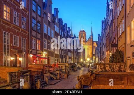 Night scene along the historical Mariacka Street in Gdansk, Poland towered by the St Mary Church (Basilica of the Assumption of the Blessed Virgin Mar Stock Photo