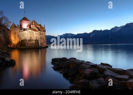 MONTREUX, SWITZERLAND - DECEMBER 4: Chateau de Chillon, Switzerland at sunset time reflecting in the waters of Lake Geneva (Leman) on the evening of D Stock Photo