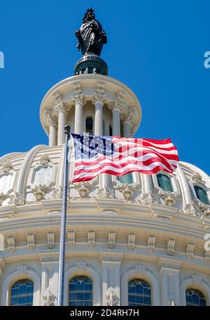 US Capitol dome and American waving flag in Washington DC with blue sky ...