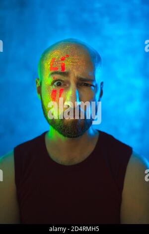 Portrait of young bearded man with glowing body art. Beautiful fantastic drawing on skin. Stock Photo