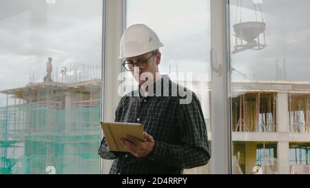 Engineer working on tablet in hand on construction site. Stock Photo