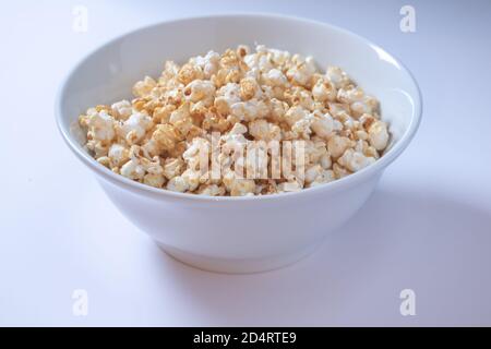 White bowl with popcorn on white background Stock Photo
