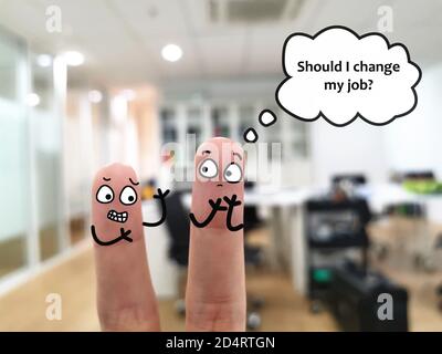 Two fingers are decorated as a boss and a worker in the office. The worker is thinking if he should change his job. Stock Photo