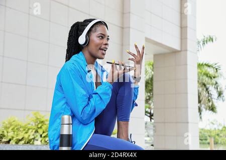Sportswoman recording voice message Stock Photo
