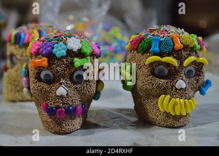 MEXICO CITY, MEXICO - OCTOBER 10: A worker decorates an amaranth skull during the manufacture to offer to customers during Dia de Muertos celebrations. The Candy Factory 'Dulceria Juanita', who have been dedicated to the production of sweets for more than 30 years, have been affected due to low sales due to the new Covid-19 pandemic. Their production of sweet, amaranth and tamarind skulls has reduced to 70 percent, manufacturing only a thousand skulls due to the fact that they have not been sold due to the crisis caused by the Coronavirus pandemic, in previous years the production of amarant Stock Photo