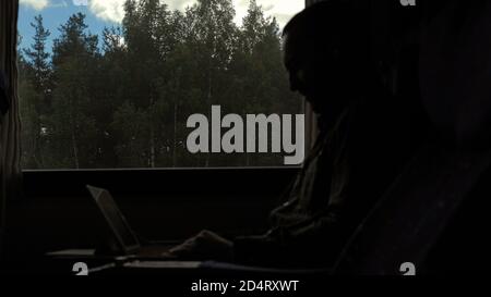 Disappointed man working on a tablet in a train. Stock Photo