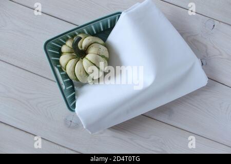 Turquoise basket with white fabric and decorative pumpkin. Stock Photo