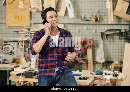 Carpenter talking on phone Stock Photo