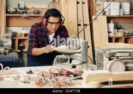 Craftsman cutting wooden plank Stock Photo