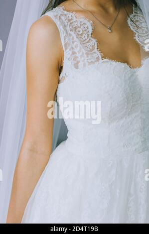 Details of a wedding dress. Close up of faceless girl in beautiful white wedding dress. Stock Photo