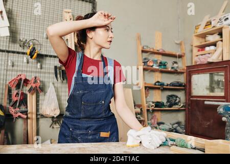 Female carpenter wiping sweat Stock Photo