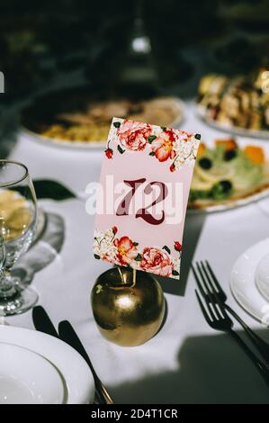 Table number twelve. Interior of restaurant for wedding dinner, ready for guests. Stock Photo
