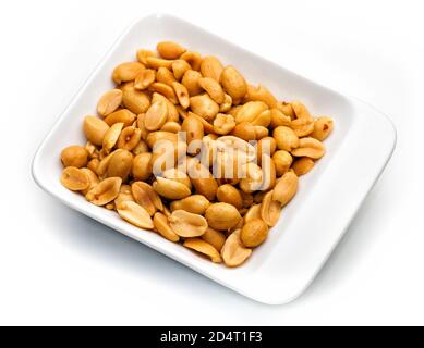 Peanuts in white container on white background. Detailed image taken with macro lens. Stock Photo