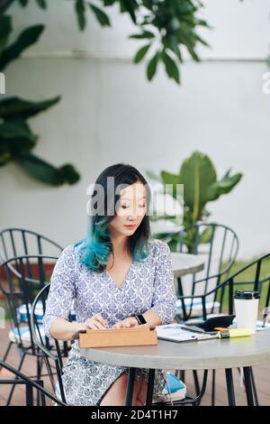 Chinese businesswoman working in cafe Stock Photo