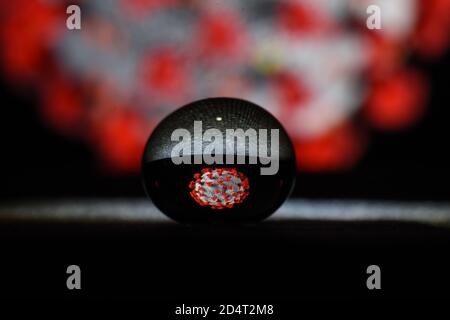 View of water gel reflecting coronavirus model, virus spreading on surfaces concept. Stock Photo